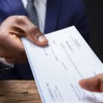 Employer handing a employee a paycheck that is long overdue.