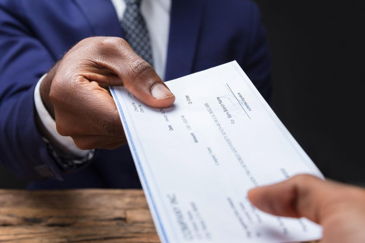 Employer handing a employee a paycheck that is long overdue.
